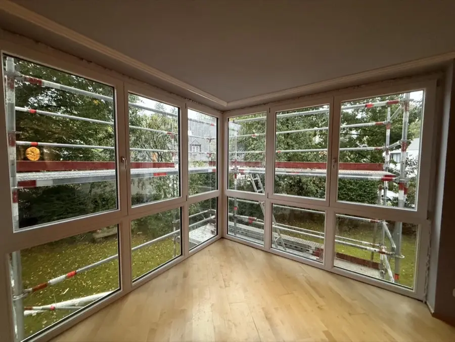 Bodentiefe Eck-Fensterfront in einem Wohnraum mit Parkettboden